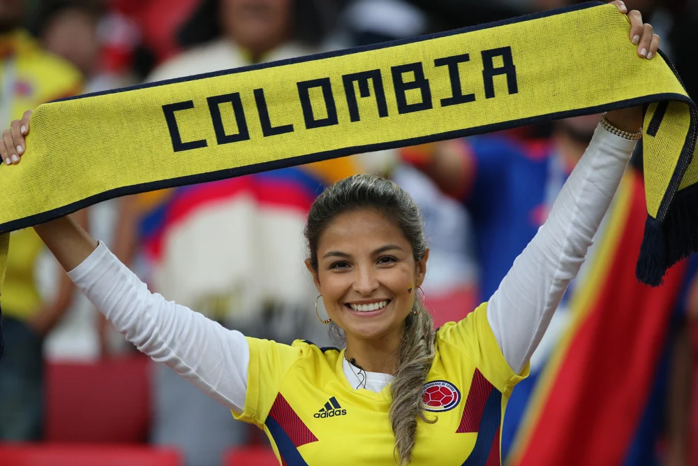 Colombian female fan holding up a scarf