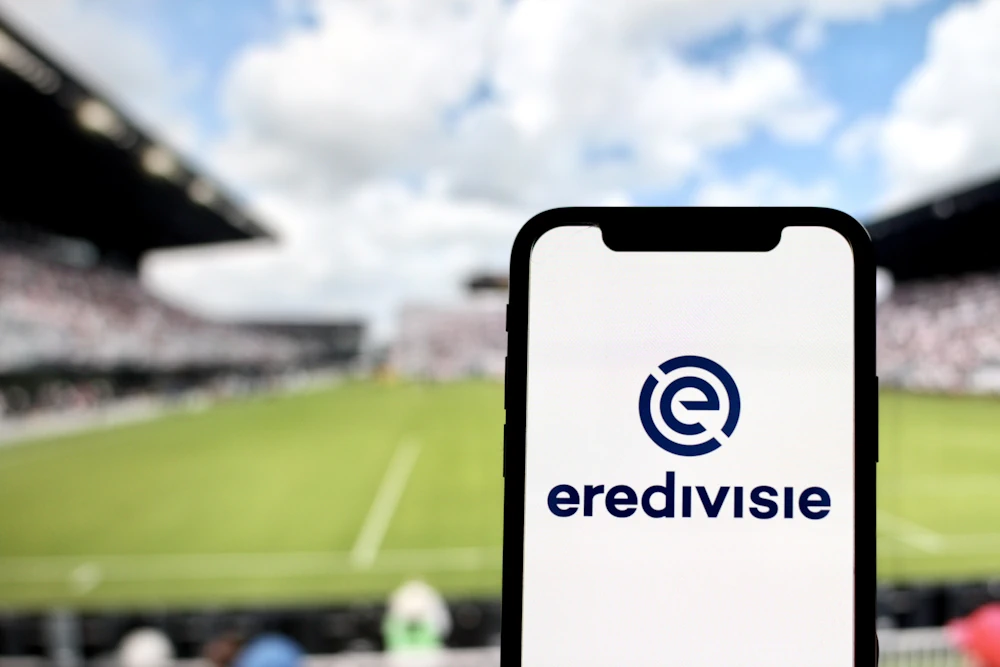 Eredivisie logo  on phone with football pitch in the background